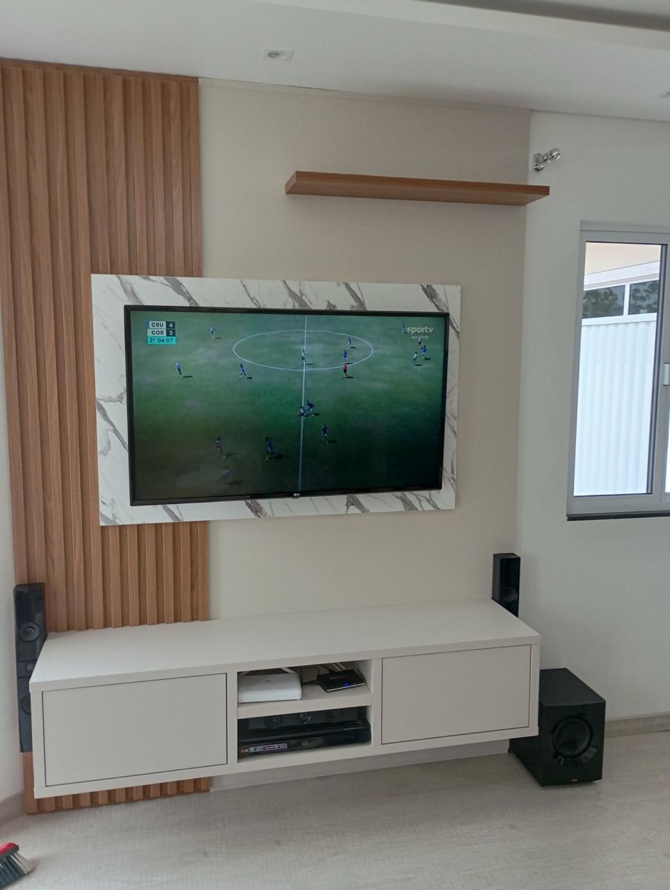 Home theater planejado com ripado e painel marmorizado