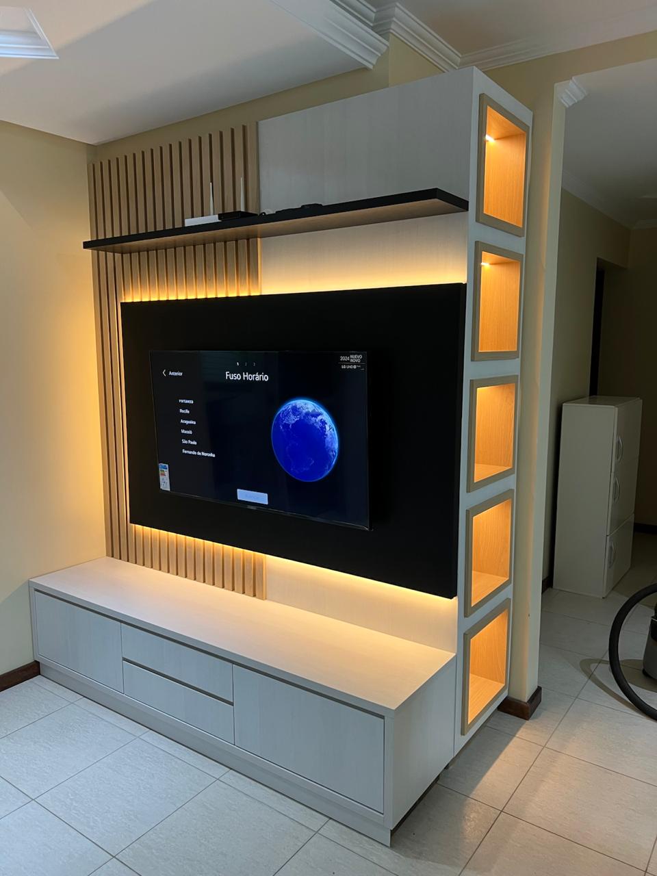 Painel de TV sob medida com ripado, nichos e iluminação em LED